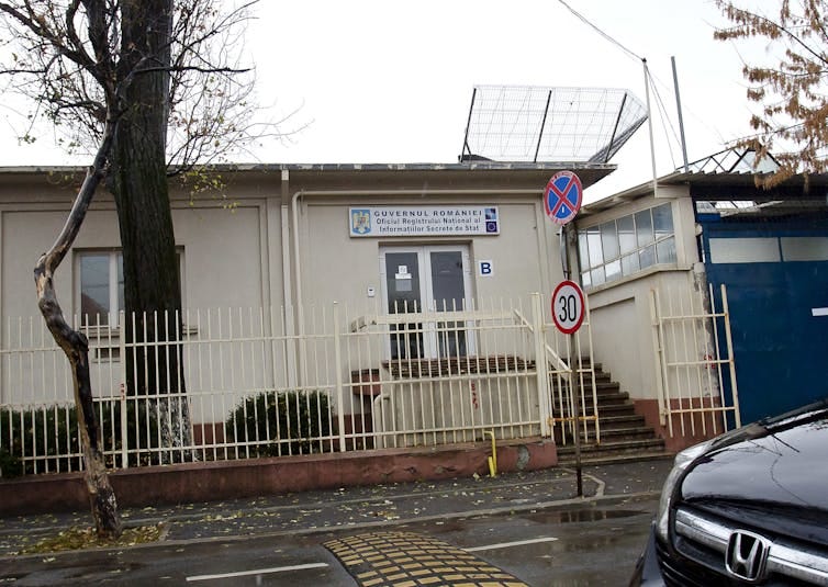 A beige one-story building with a sign above the door.