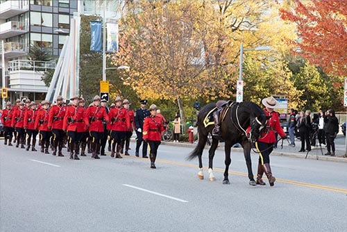 Unmounted horse and members in red serge marching