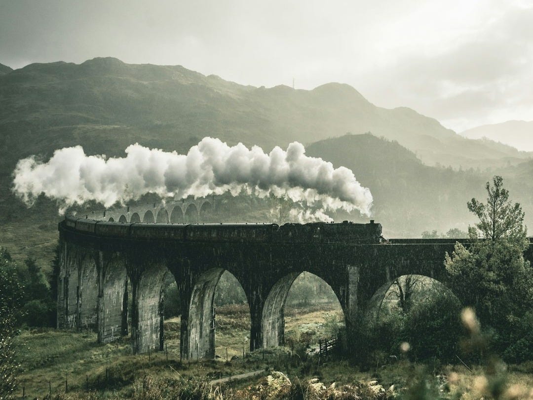 black train on railway bridge under heavy clouds black train on railway bridge under heavy clouds