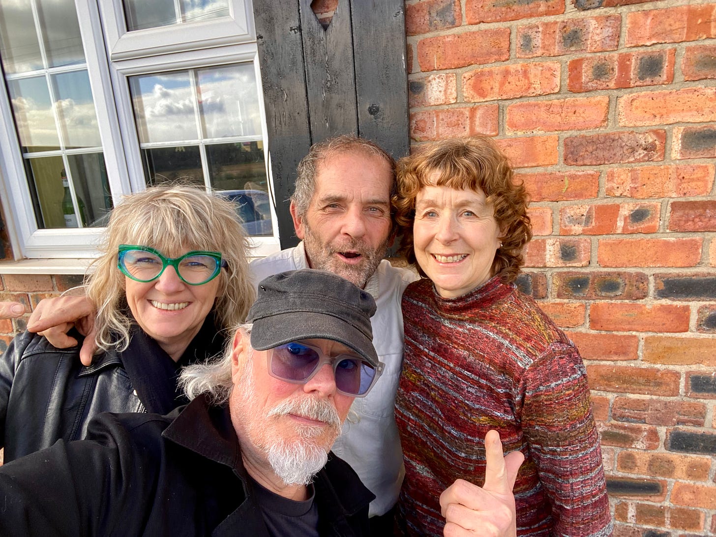 Four people smiling in front of a house