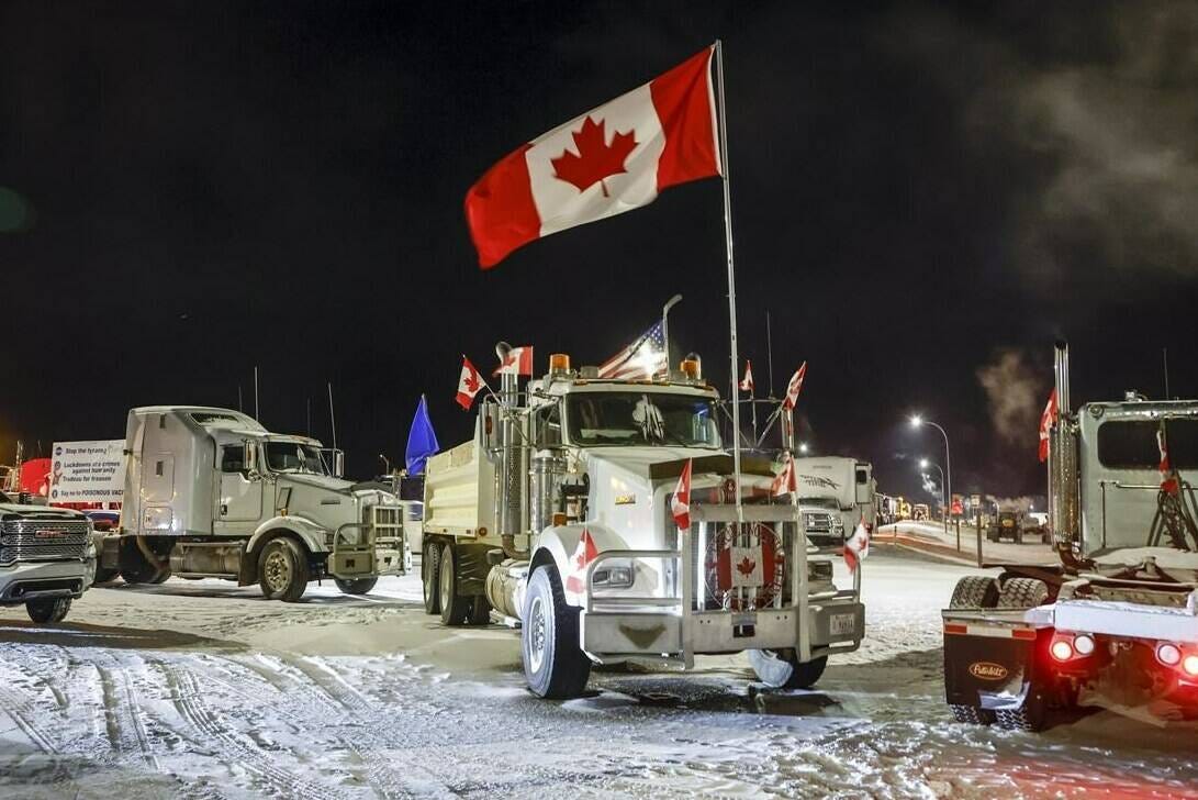 Anti-COVID-19 vaccine mandate demonstrators gather as a truck convoy blocks the highway at the busy U.S. border crossing in Coutts, Alta., Tuesday, Feb. 1, 2022. A Calgary pastor is expected to learn today whether he will be found guilty for his participation in a convoy protest last year that blocked Alberta's main border crossing into the United States. THE CANADIAN PRESS/Jeff McIntosh