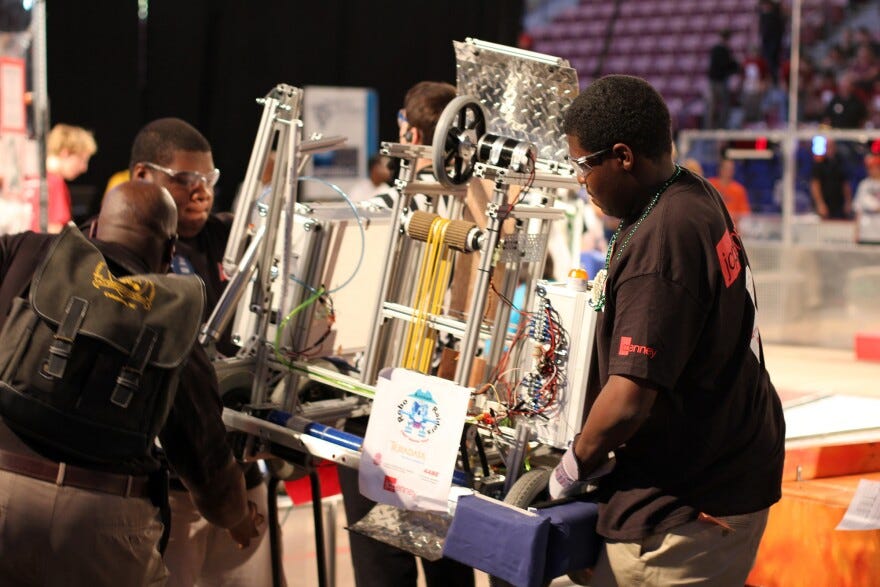 Young people move robotics equipment.