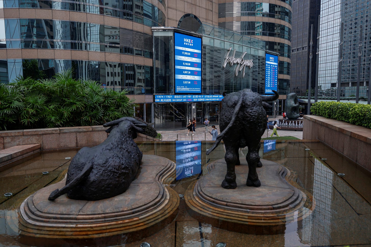 Bull statues are placed in font of screens showing the Hang Seng stock index and stock prices outside Exchange Square, in Hong Kong