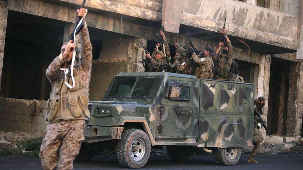 Rebel fighters celebrate after they captured Maaret al-Numan in Syria's north-western Idlib province (30 November 2024)