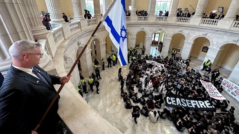 Rep. Brandon Williams (R-NY) dangles an Israeli flag over protesters, many of whom said they are Jewish, as they hold a civil disobedience action calling for a cease fire in Gaza and an end to the Israel-Hamas conflict while occupying the rotunda of the Cannon House office building on Capitol Hill in Washington, U.S., October 18, 2023. REUTERS/Jonathan Ernst
