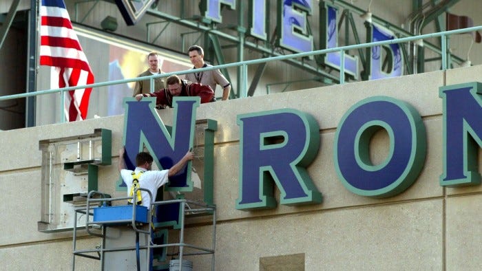 402709 01: Stadium employees remove letters from one of the Enron Field signs March 21, 2002 in Houston, TX. The Houston Astros paid $2.1 million to get back the naming rights to their stadium from collasped energy trader Enron. (Photo by James Nielsen/Getty Images)