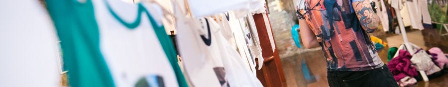 Clothes are hanging to dry outside. There is a person wearing a shirt with a photo of more clothes drying.