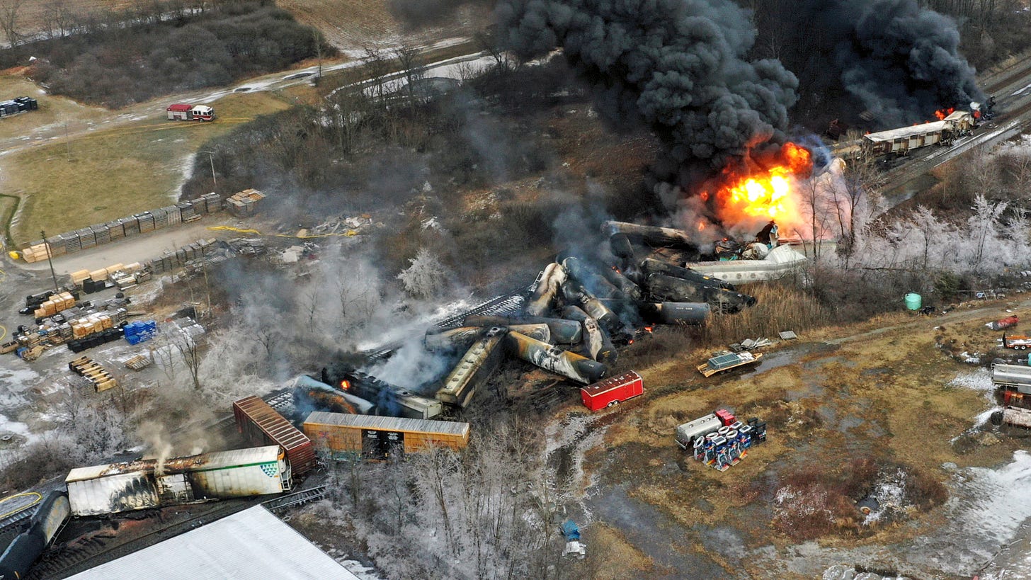 A shot from above of a massive train derailment. The burning husks of train cars are piled up like dynamited logs.