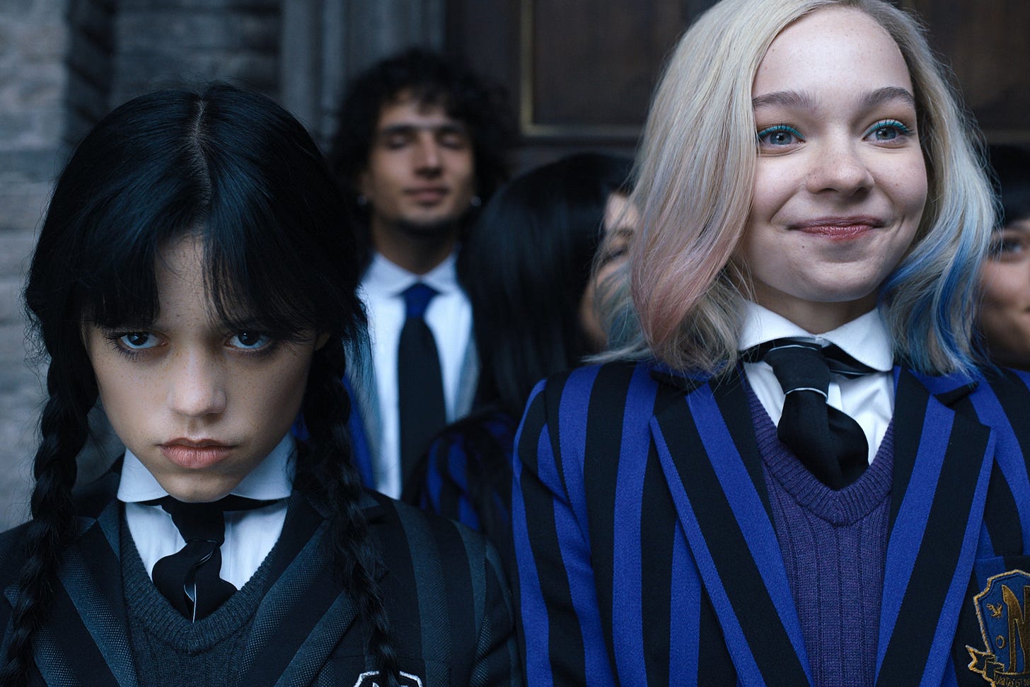 Left, a girl with an expressionless face and black braids. Right, a girl with blonde hair and a big smile. Left, a girl with an expressionless face and black braids. Right, a girl with blonde hair and a big smile.