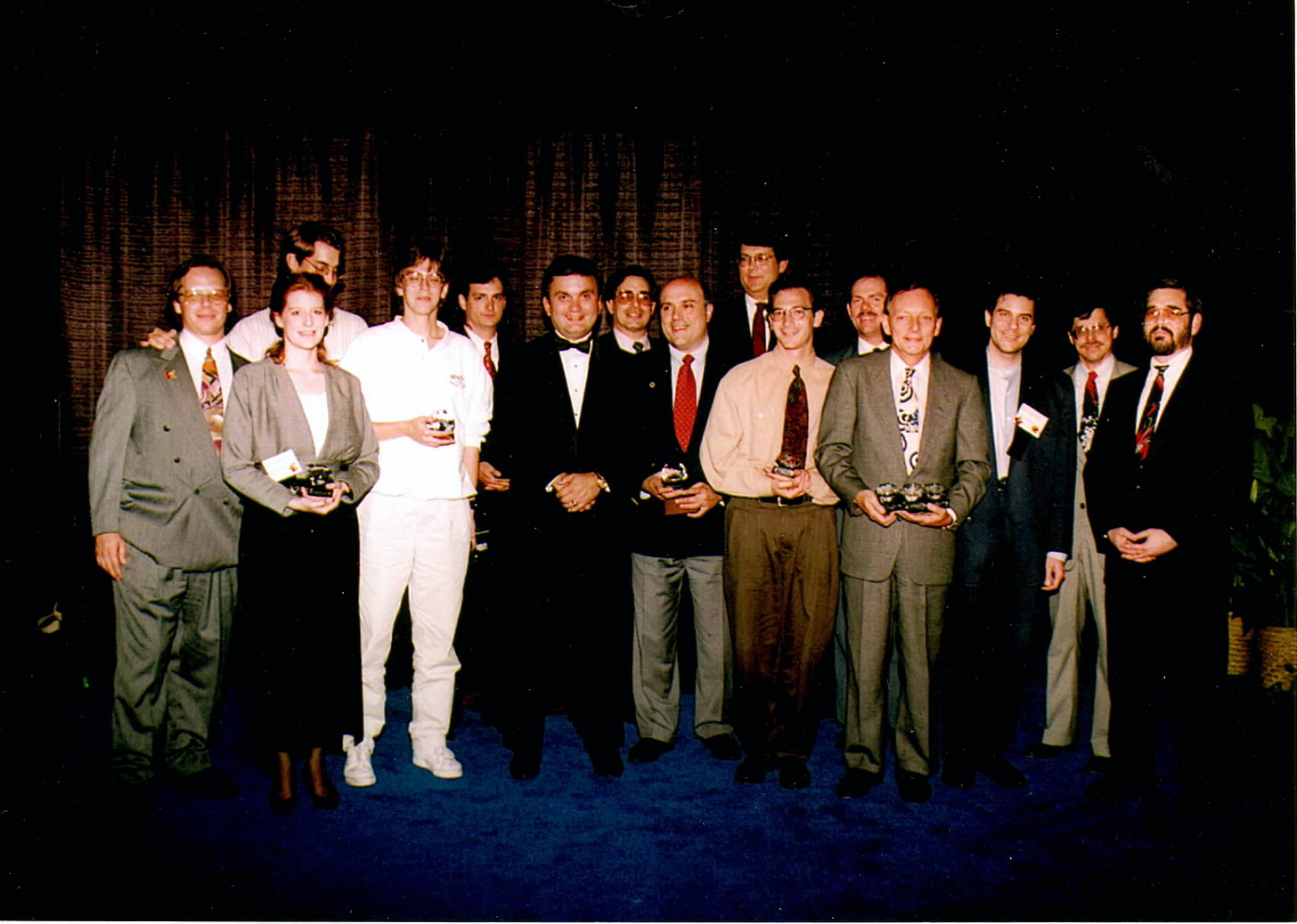 A photograph of Carol accepting the award with others winners at the 1994 Diamond Gem Awards, on stage with Steve Geppi