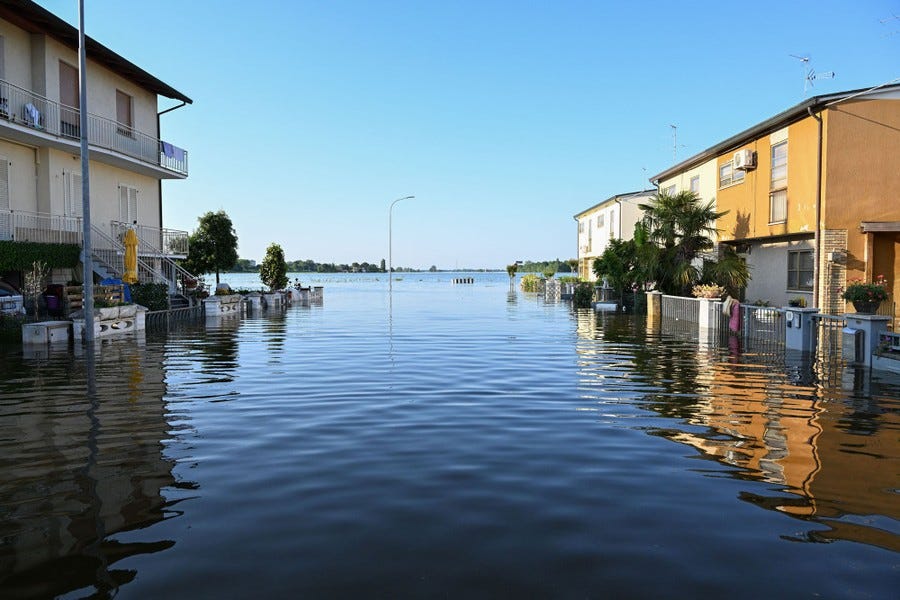 A view of a flooded street leading into an open area that is also flooded.