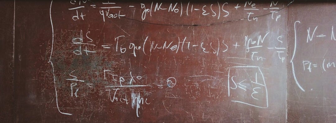 written equations on brown wooden board