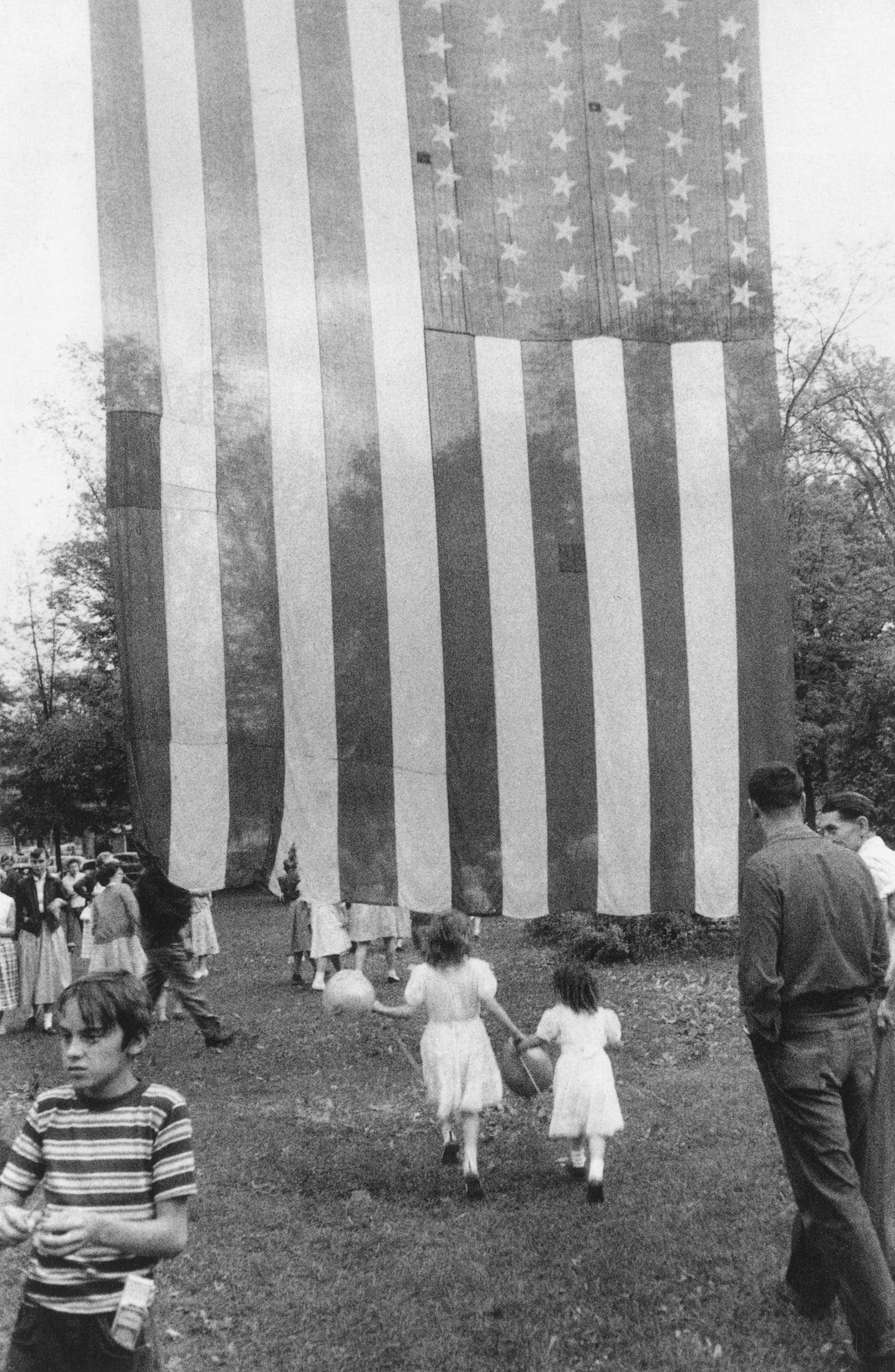 Two girls under American flag.