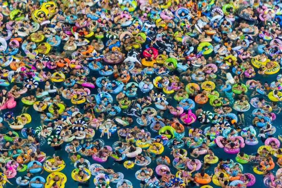 Hundreds of people float side by side in a wave pool.