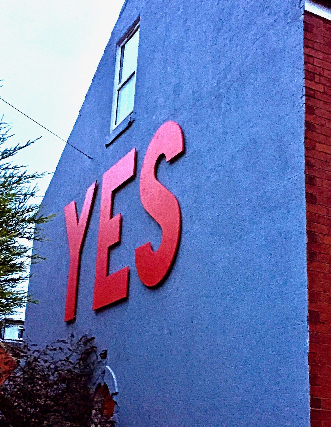 House wall with "Yes" in large letters