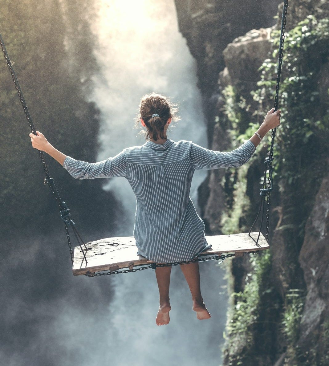 woman riding on wooden swing woman riding on wooden swing