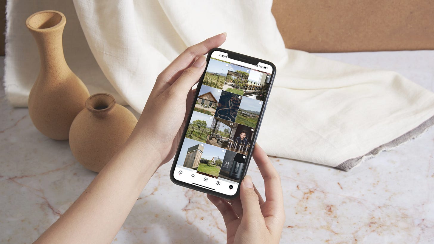 Hands holding an iphone with the Brave & Maiden Instagram feed pulled up on the screen against a white marble backdrop Hands holding an iphone with the Brave & Maiden Instagram feed pulled up on the screen against a white marble backdrop