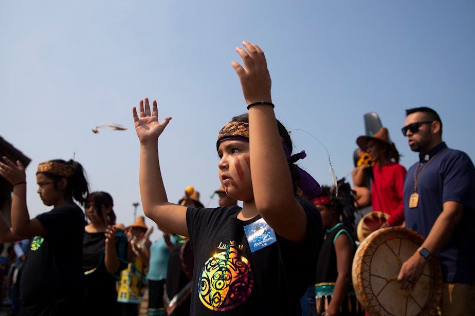 caption: Lummi tribal members dance and sing songs during a celebration of life for Tokitae on Sunday, August 27, 2023, at Jackson Beach Park on San Juan Island. 