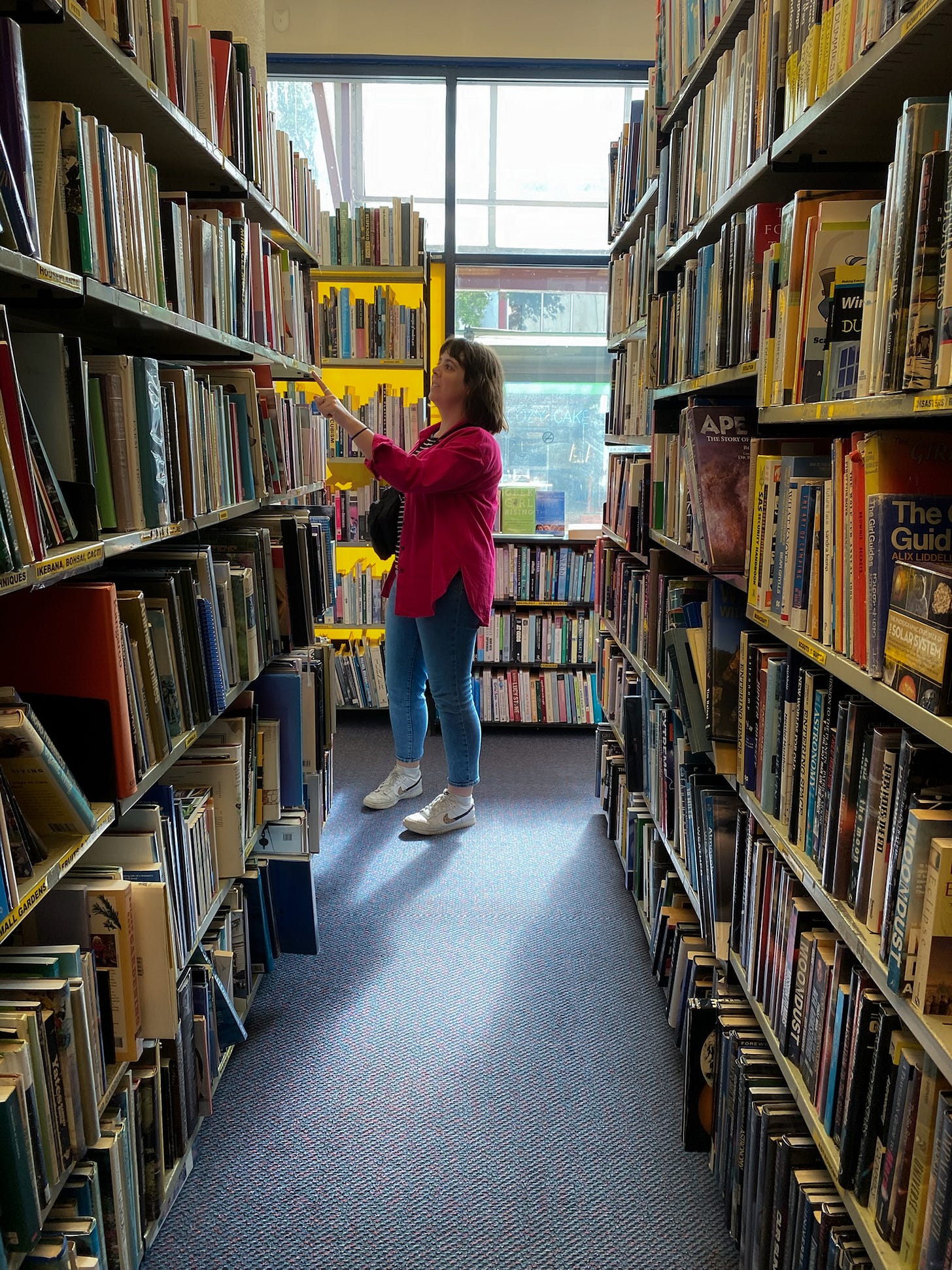 Food and travel writer Courtney Jill Bishop in a used bookstore recommendations for novels that feel like a vacation. 