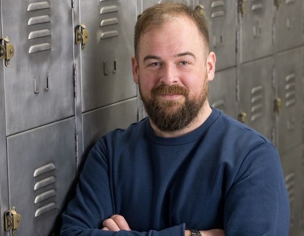 (Image: Construct3) Thomas Gullen posing behind photo background