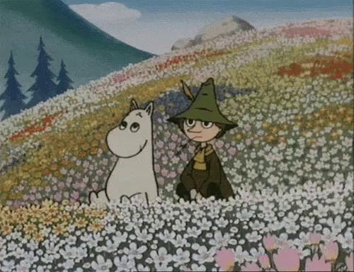 Snufkin and Moomin sitting in a field of flowers.