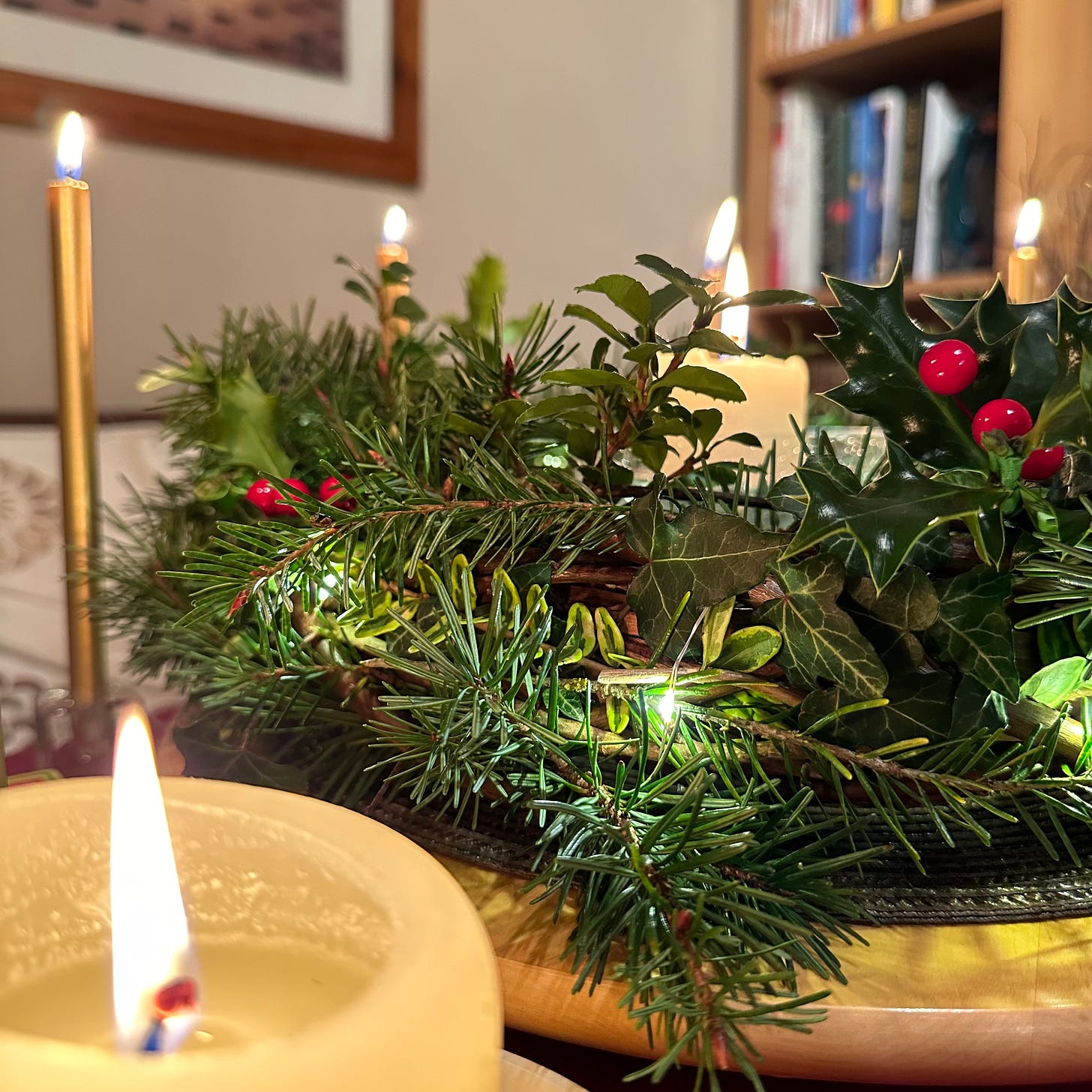 A table decoration made with garden foliage and lit by candles.