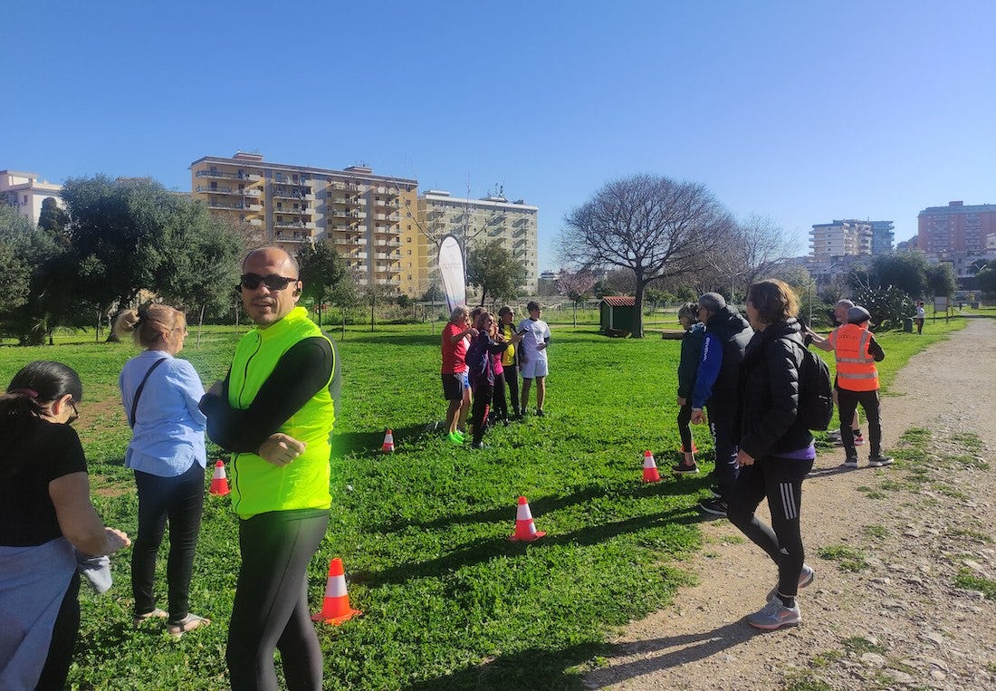 A group standing by a parkrun flag having photos taken