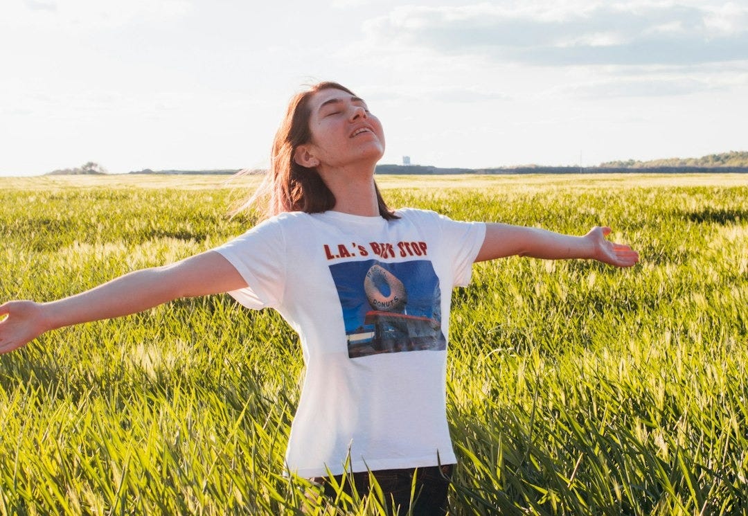woman standing in green field woman standing in green field