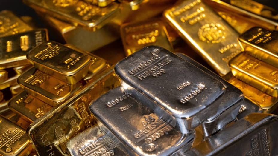 Gold and silver bars of various sizes lie in a safe on a table at the precious metals dealer Pro Aurum in Munich.