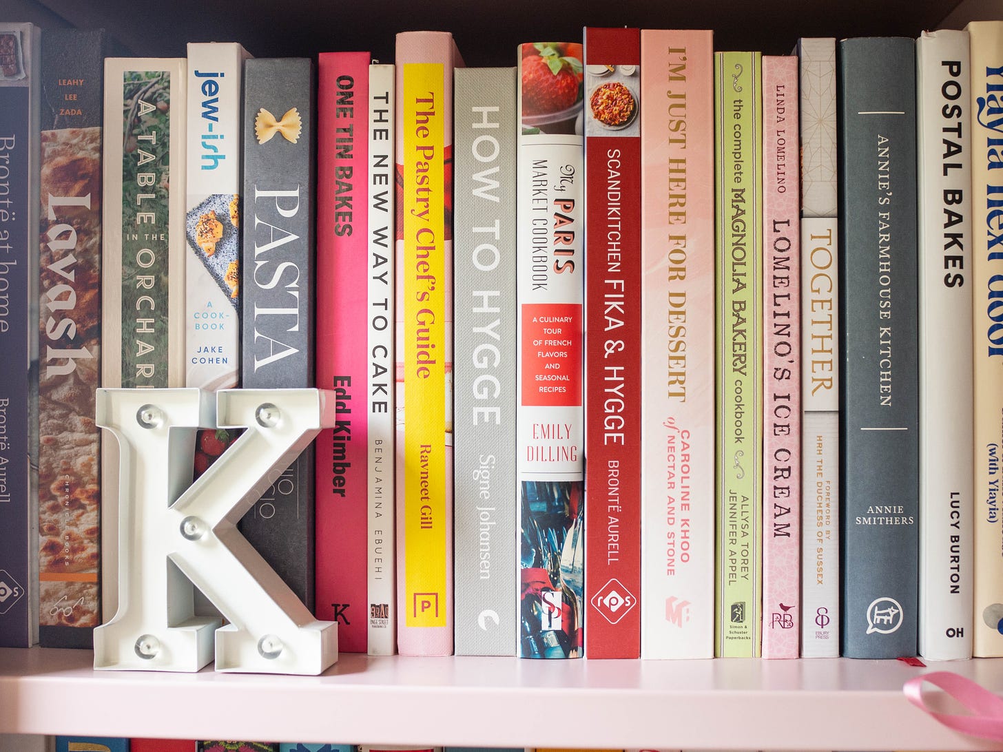 cookbooks on pink shelf