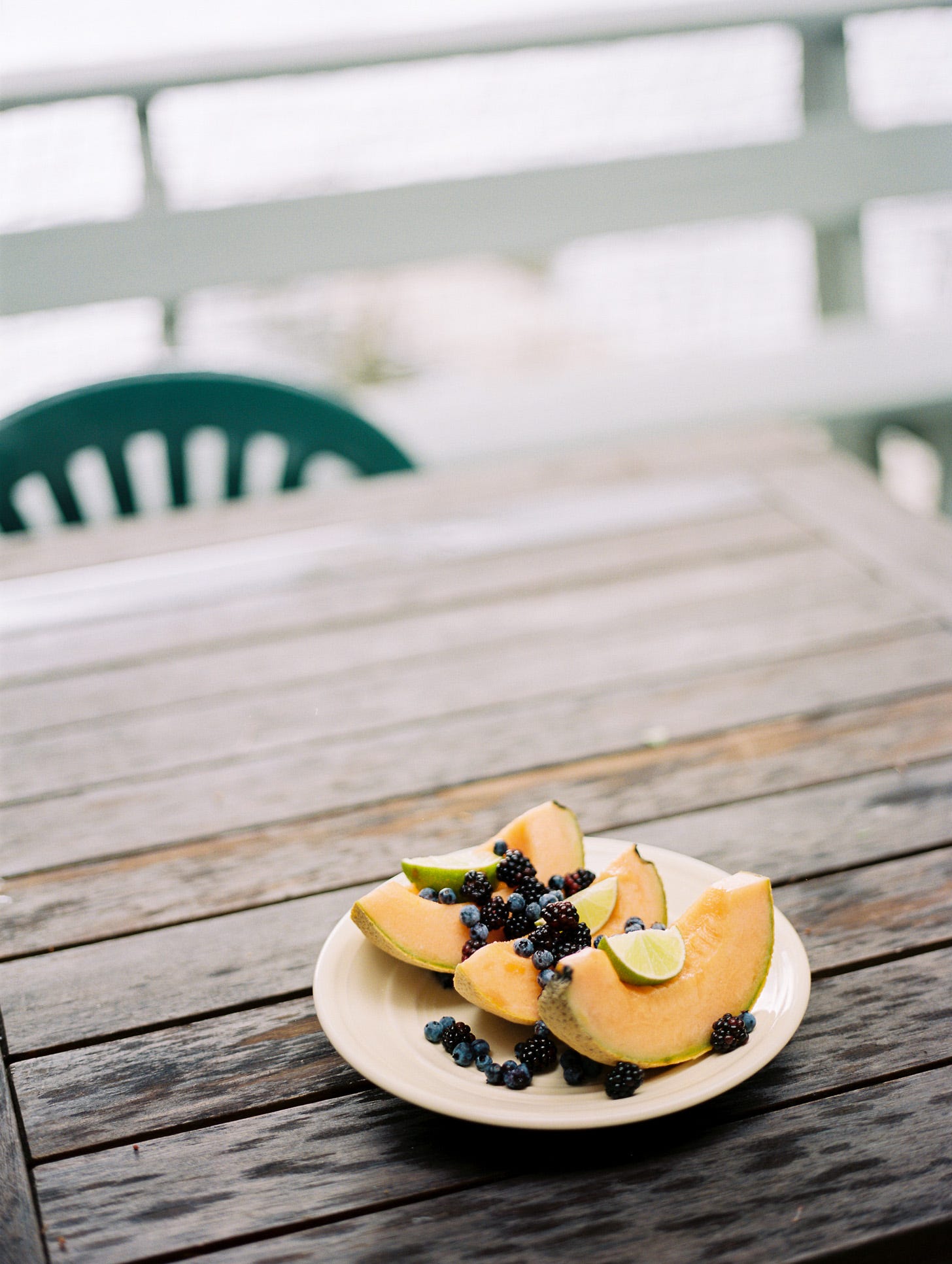 Photo of melon slices and berries on a picnic table