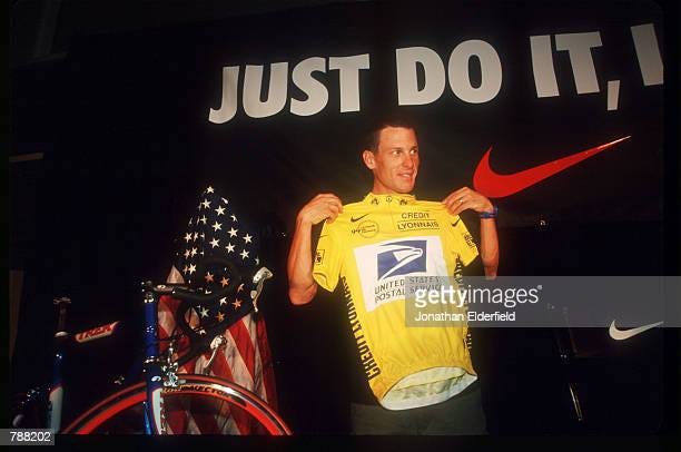 Lance Armstrong holds up a yellow shirt at the Niketown Celebration... News  Photo - Getty Images
