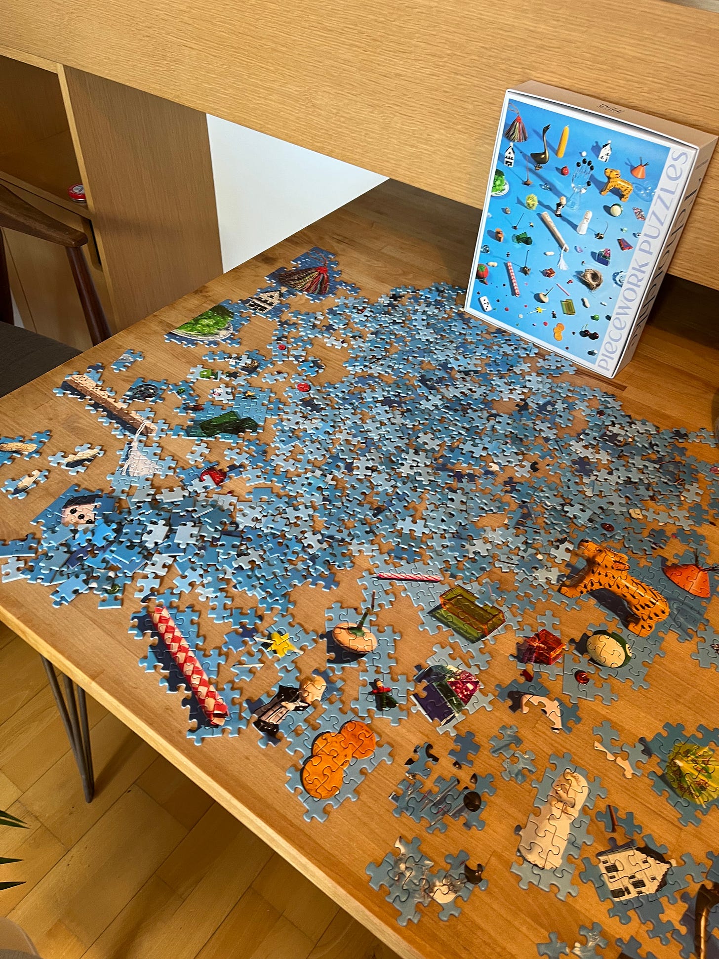 A table covered with an incomplete jigsaw puzzle.