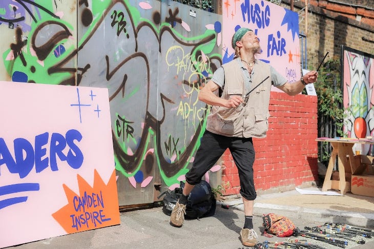 A street performer giving a show against a graffiti wall backdrop