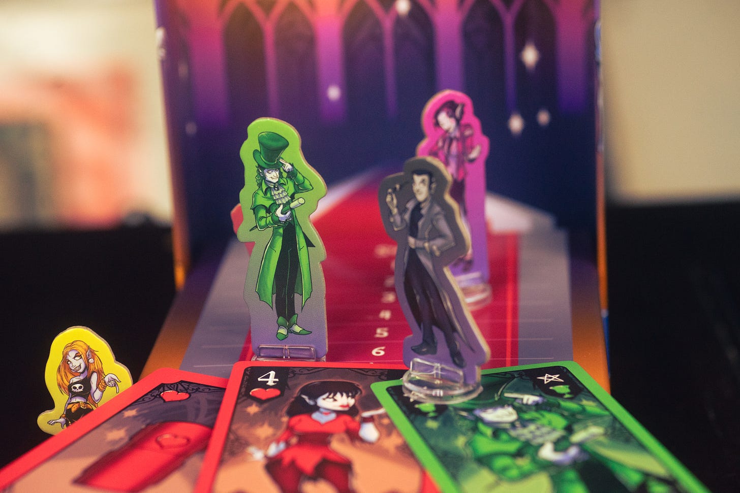 The card game Vamp on the Batwalk displayed on a table. Several cardboard pieces depicting characters are visible on the game board.