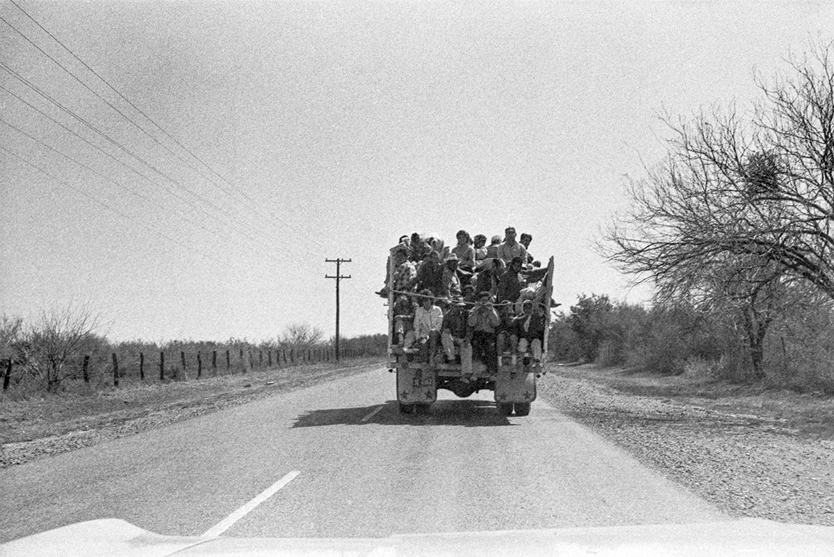 Mexican workers travel standing in the back of a truck while being transported from Mexico to a farm in Texas. South Texas, 1966. Photo by Emmon Clarke. 
