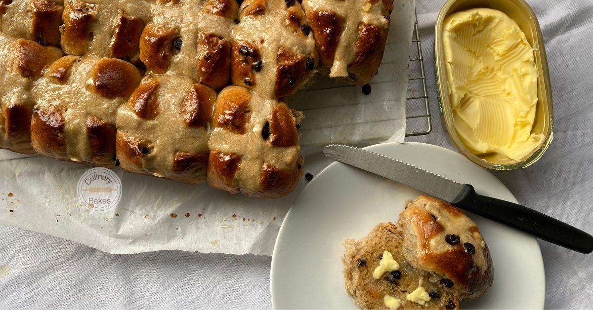 Hot Cross Buns with one sliced and buttered.