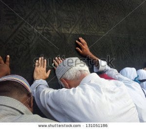 A pilgrim touches and bows before the Ka'bah during the Hajj.