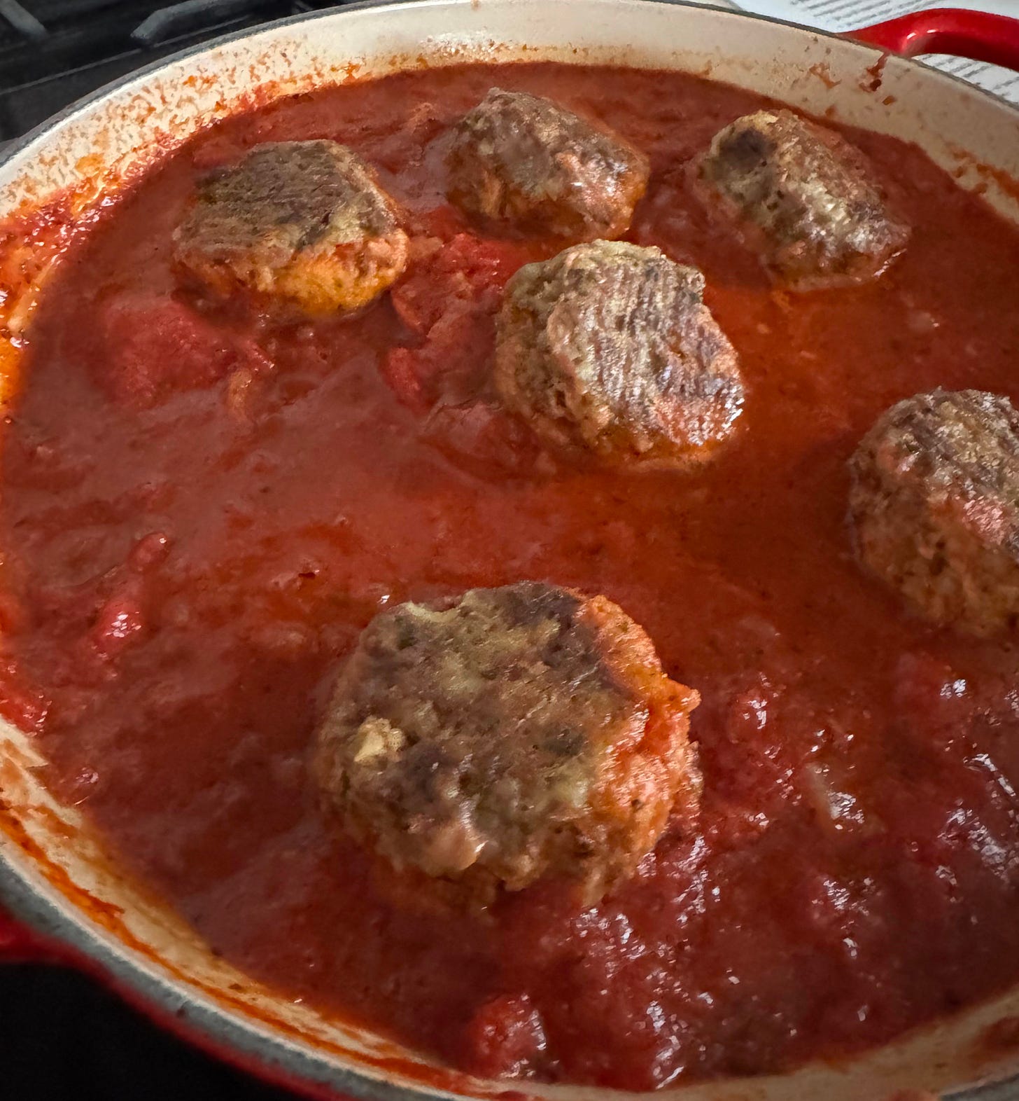 Beef meatballs simmering in marinara.