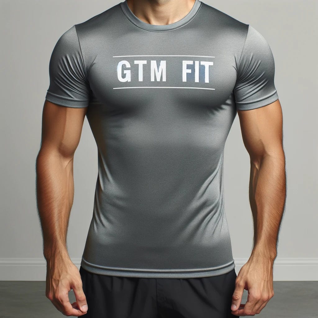 A person in good physical shape, standing confidently. They are wearing a fitted t-shirt with the text 'GTM Fit' prominently displayed on the front. The background is simple and unobtrusive, ensuring the focus remains on the individual and their shirt. The person has a friendly and approachable demeanor.