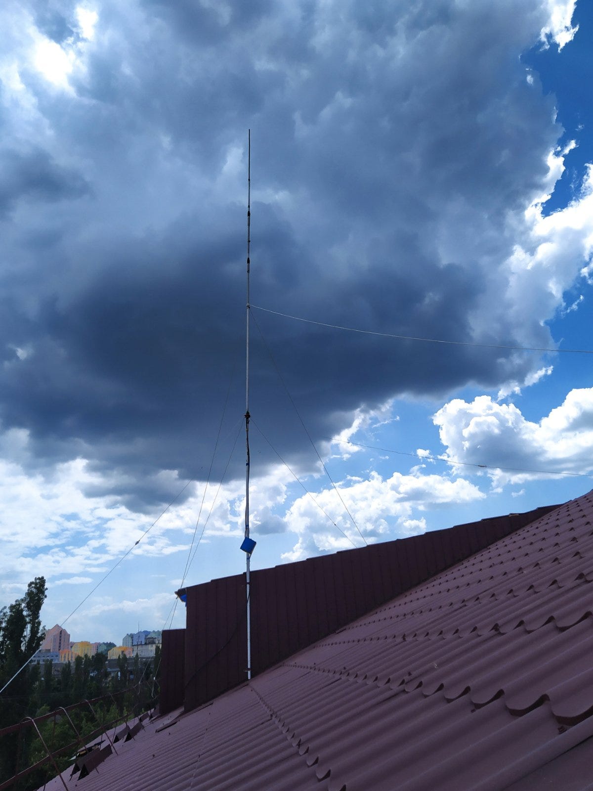 A vertical antenna on an apartment roof