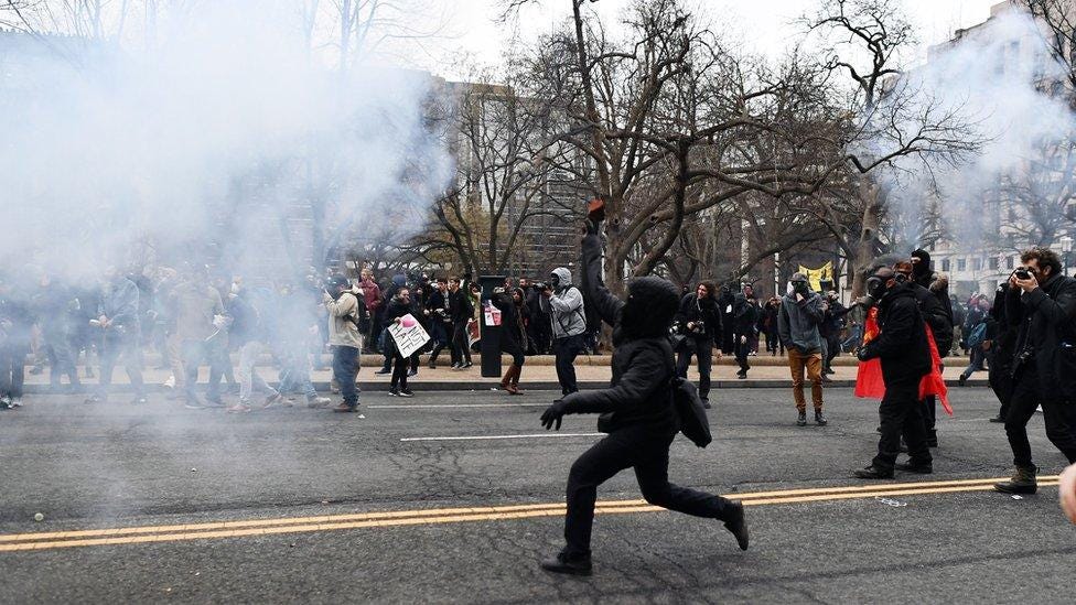 A protester lobs a brick at police during protests in Washington during the inauguration of Donald Trump