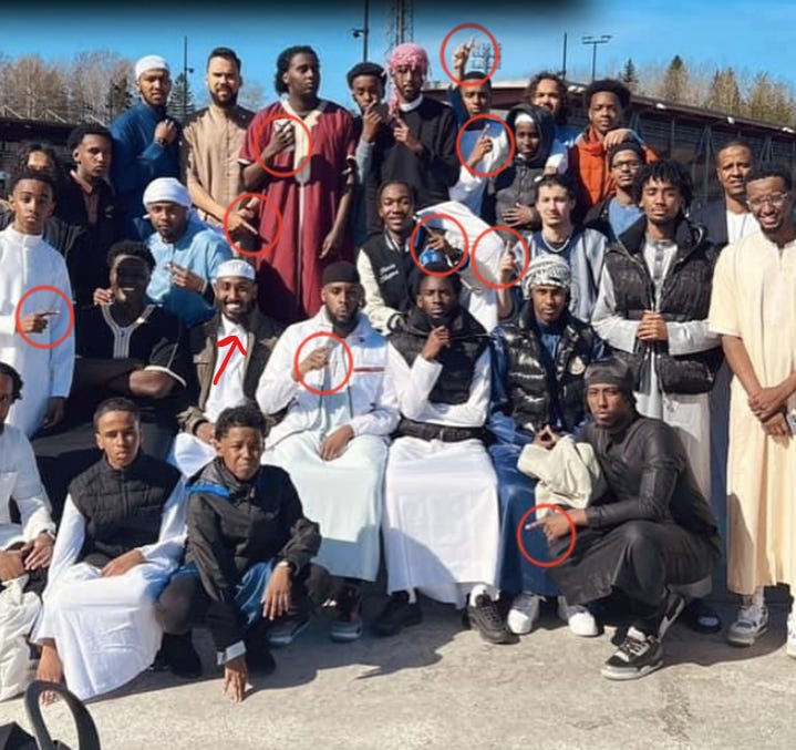 A radical imam from Vantaa and his 'congregation', showing off the ISIS 'takbir' sign.