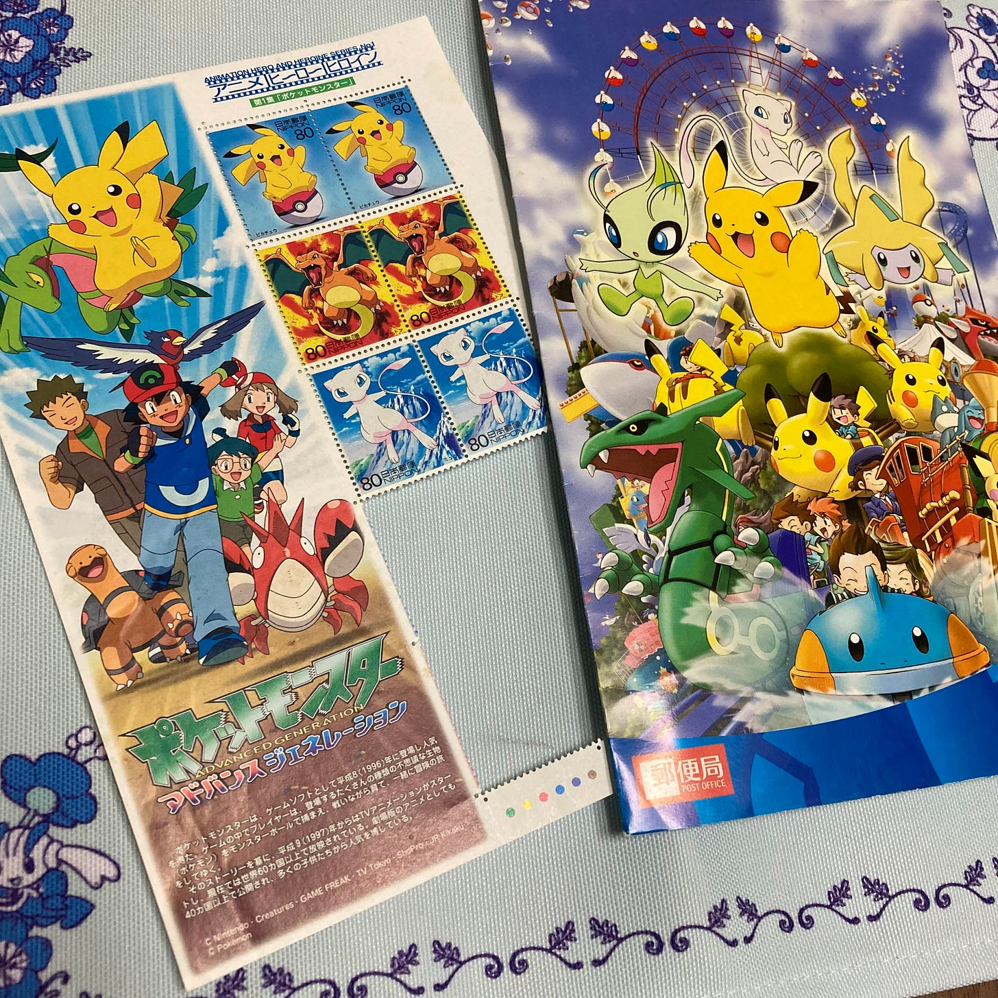 A photograph of Shiori’s stamps, featuring Pikach, Charzard, and Mew. There is also an advertisement for the Pokémon Advanced Generation anime