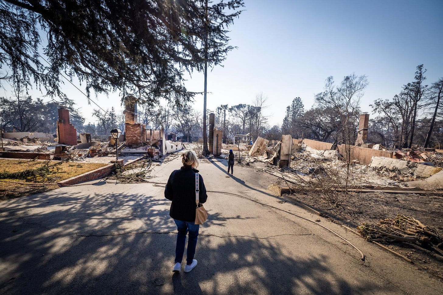 Kathryn Barger stands on a street of destroyed homes 