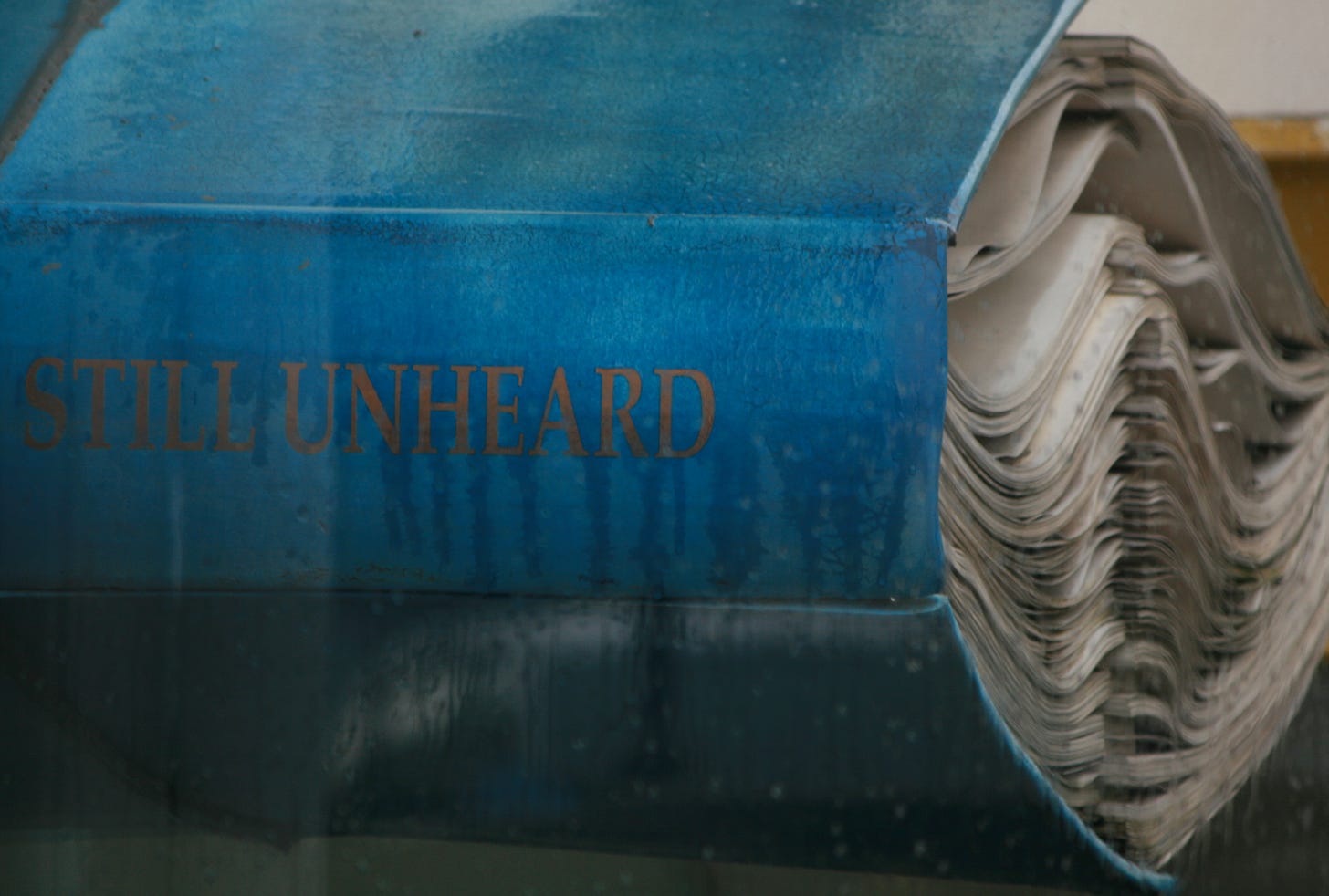 Photo of a giant blue book with title 'Still Unheard'