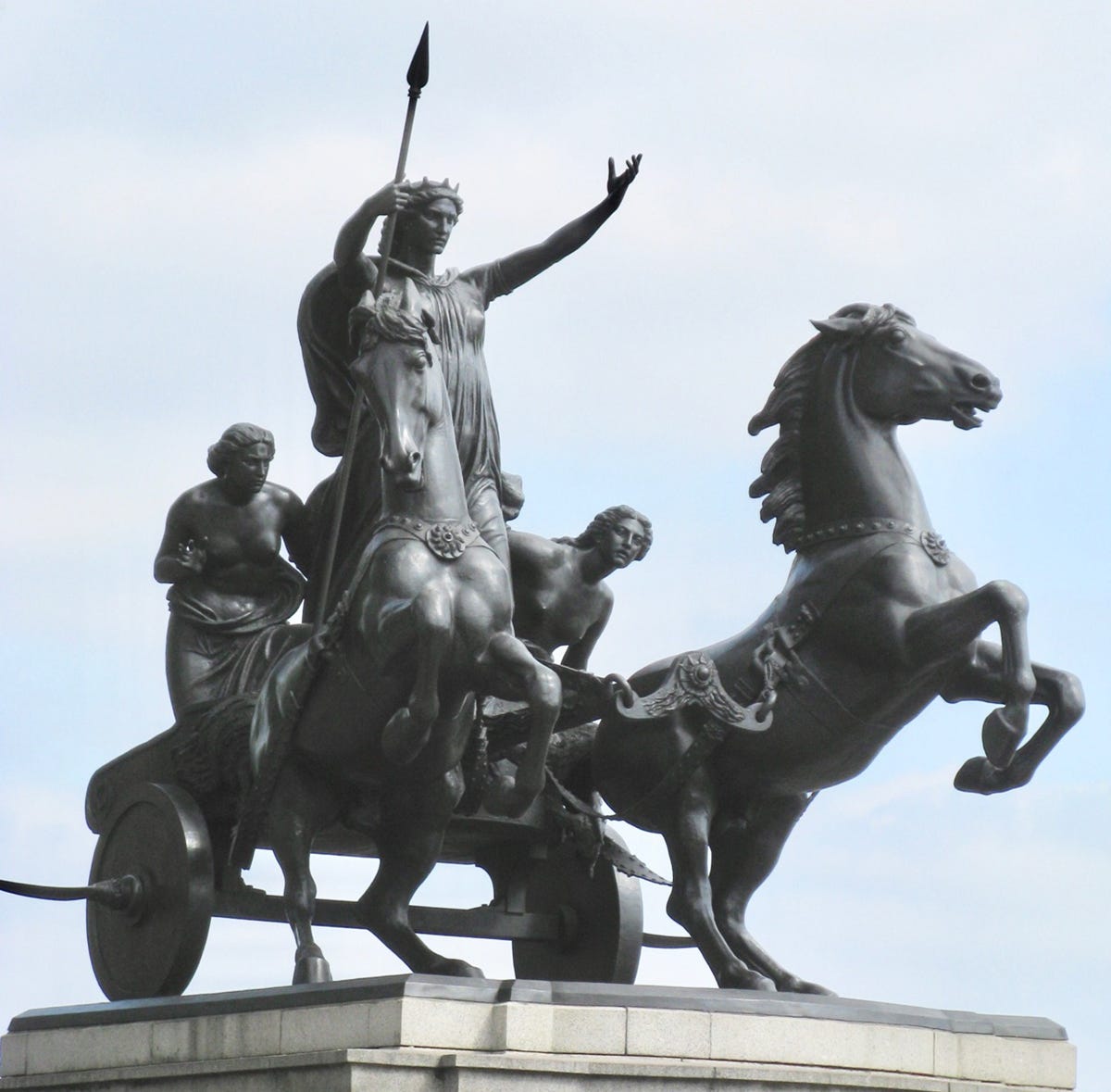 A bronze statue of three women in a cart being pulled by two horses A bronze statue of three women in a cart being pulled by two horses