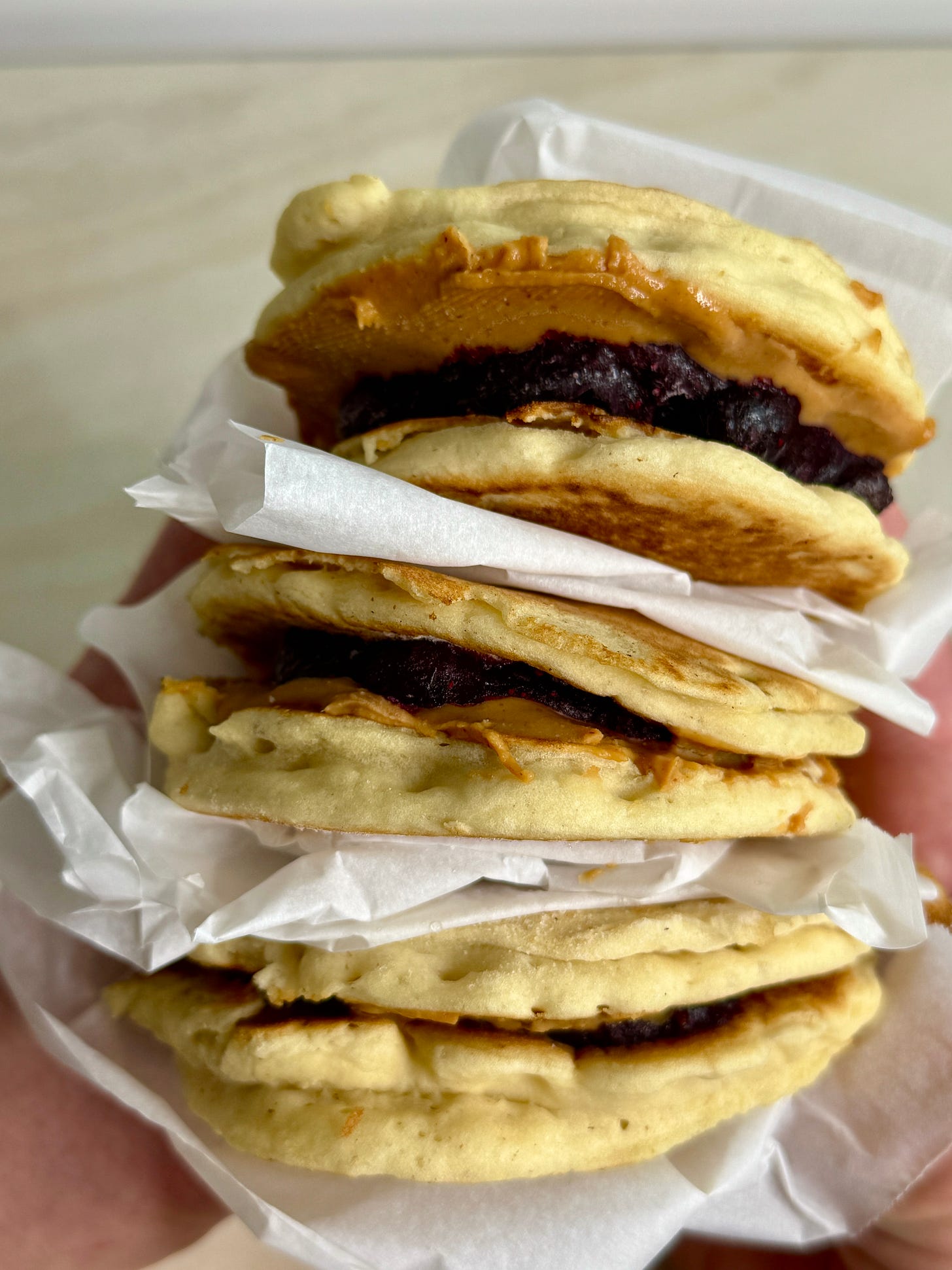 Fluffy gluten-free pancakes layered with creamy peanut butter and warm blueberry compote, stacked into satisfying breakfast sandwiches.