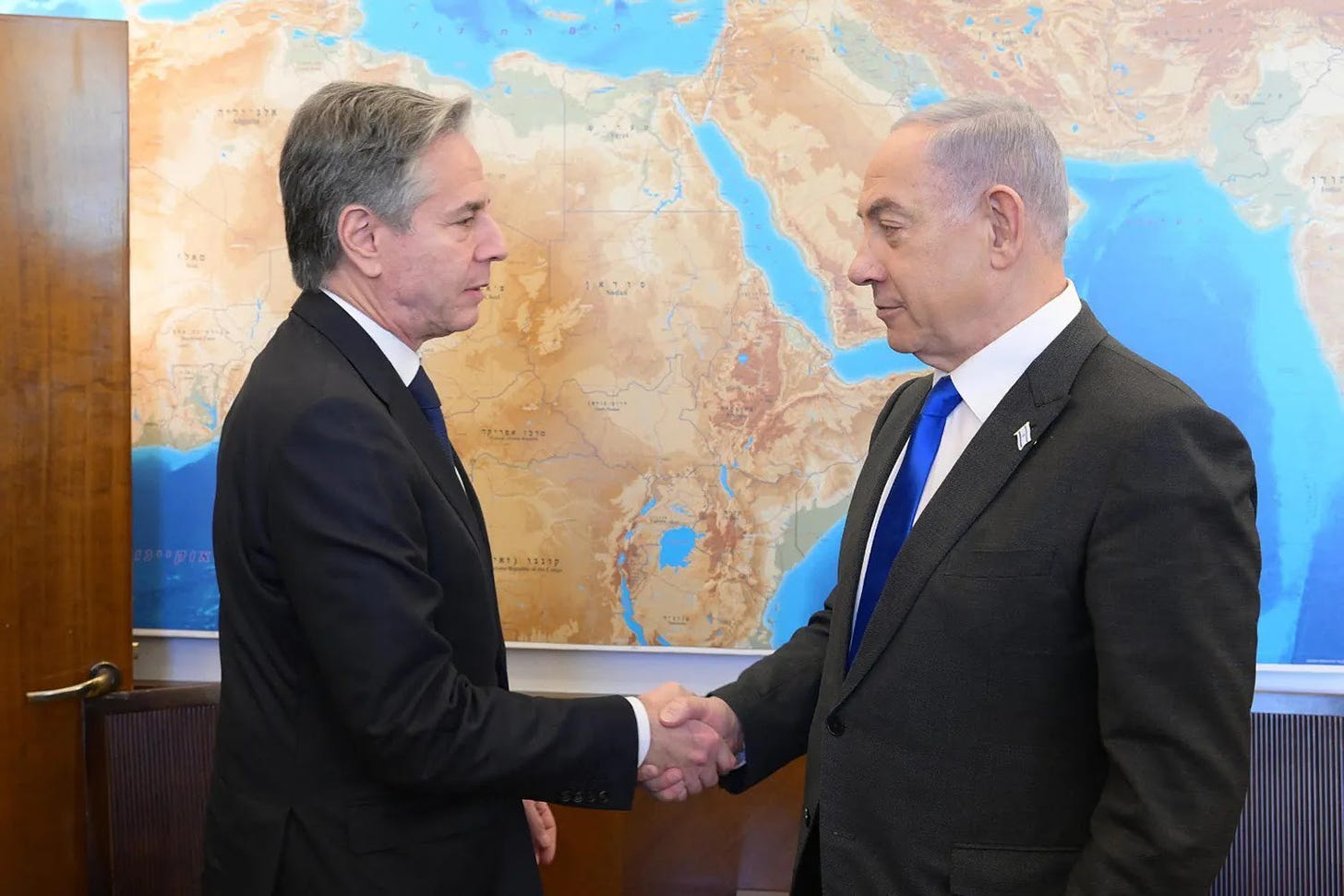 U.S. Secretary of State Antony Blinken shakes hands with Israeli Prime Minister Benjamin Netanyahu.