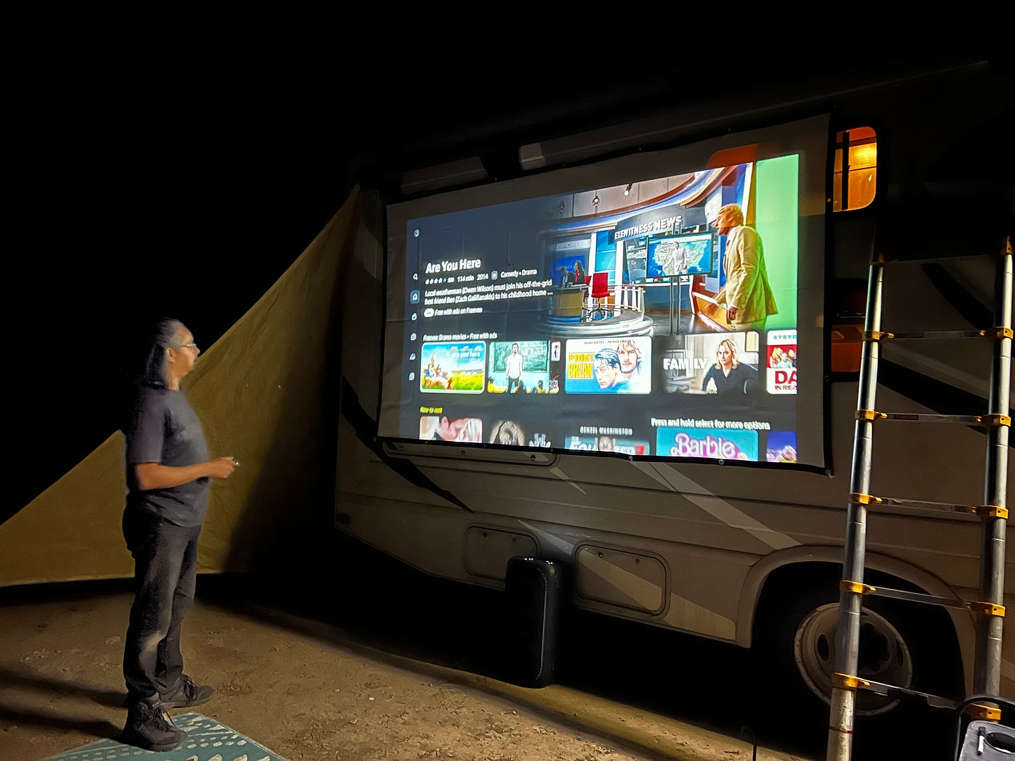 Photo of David Rivera, setting up the Projector screen on the side of the RV in the Roswell, NM Desert.